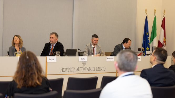 Attēlā attēloti četri delegācijas pārstāvji, kuri atrodas konferenču telpā