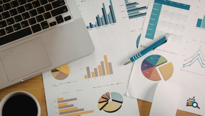 Attēlā redzams dators, pildspalva un lapas ar diagrammām