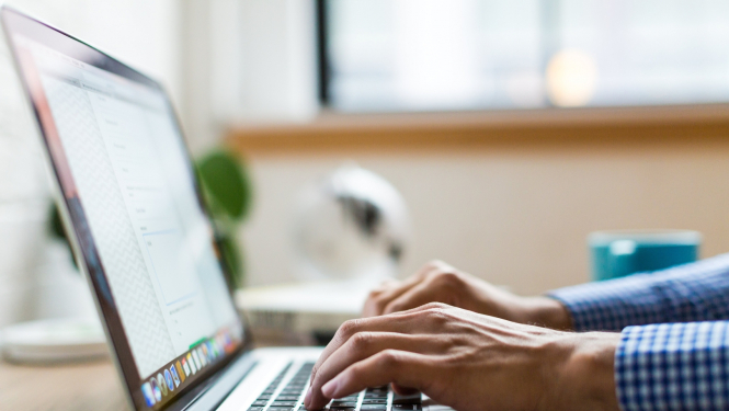 Vīrieetis lieto portatīvo datoru