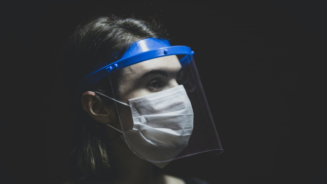 Sieviete ar sejas masku un sejas vairogu