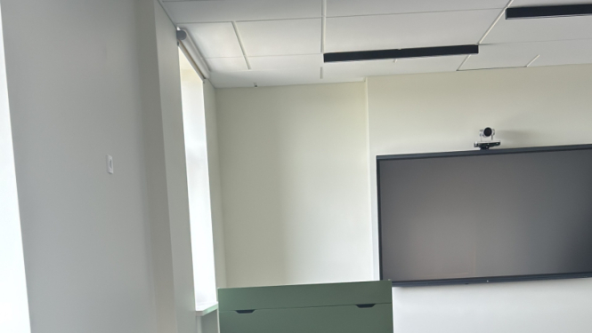 attēlā telpa kurā ir melni krēsli, tv ekrāns 