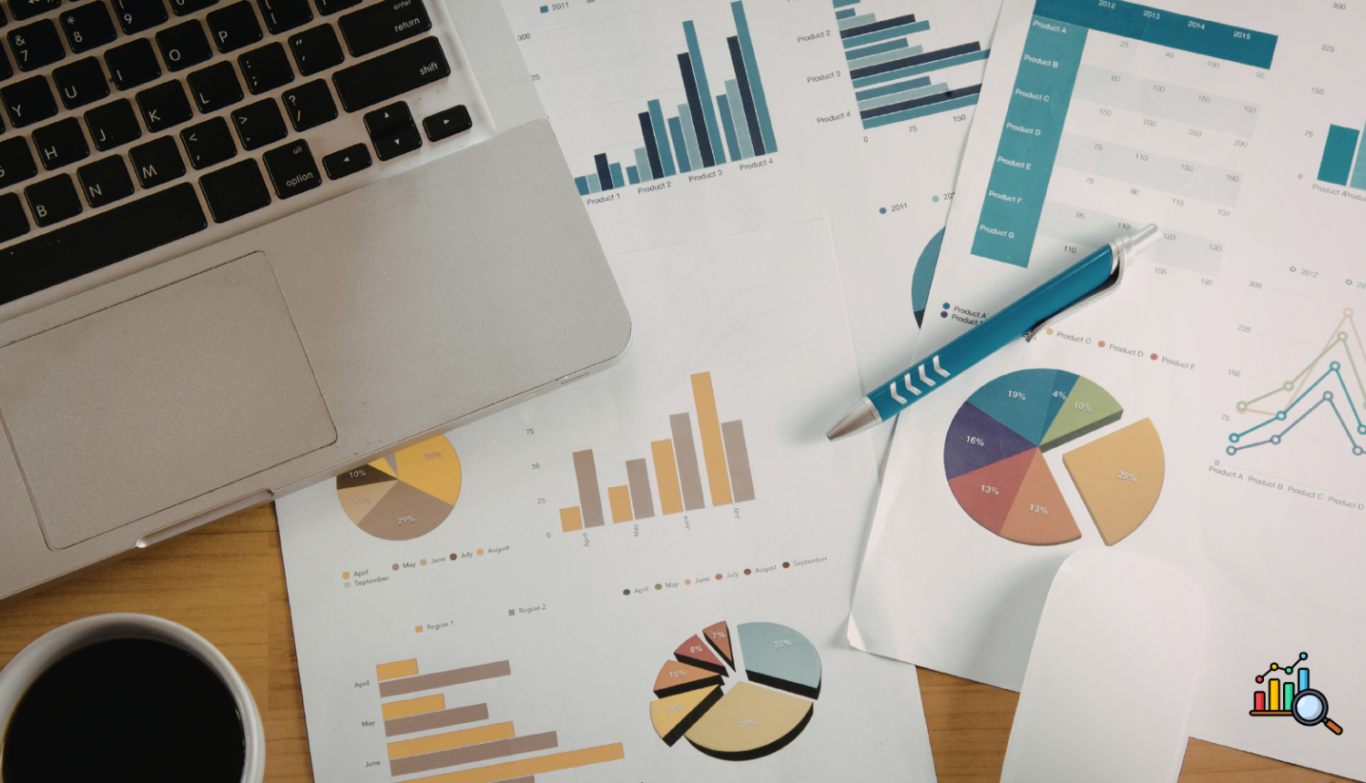 Attēlā redzams dators, pildspalva un lapas ar diagrammām