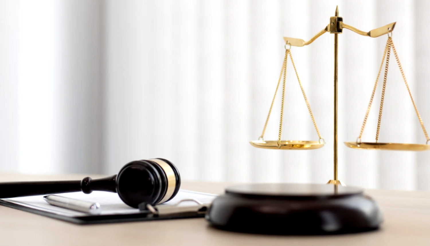 attēlā tiesas āmurs stāv uz galda