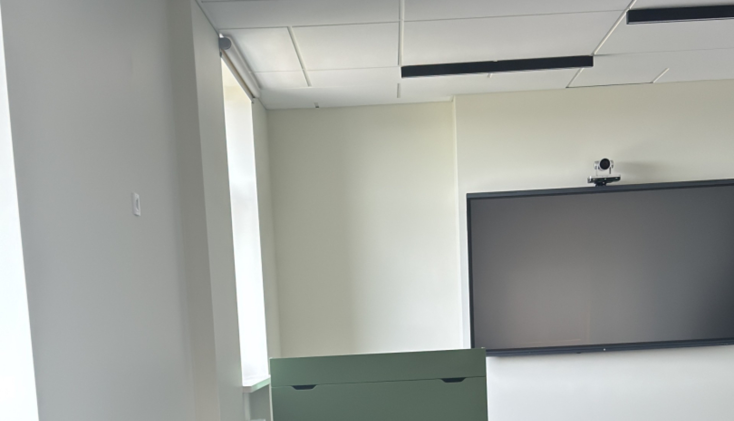 attēlā telpa kurā ir melni krēsli, tv ekrāns 